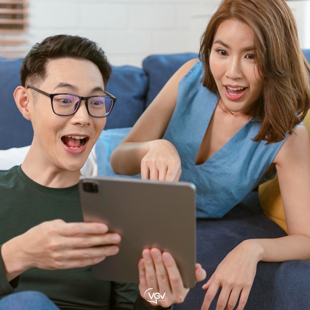 Two people are watching a video by an influencer on the sofa.